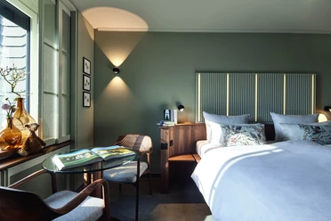 Preferred Plus Room 1-Viveno Group GmbH_L.Thiesbrummel.jpg Gemütliches Zimmer mit Doppelbett, modernem Design, blauen Akzenten und einladendem Naturlicht.