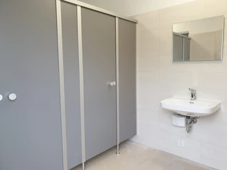 toilette_ti_werdum.jpg Zwei Türen einer Toilettentrennwand mit Waschbecken davor
