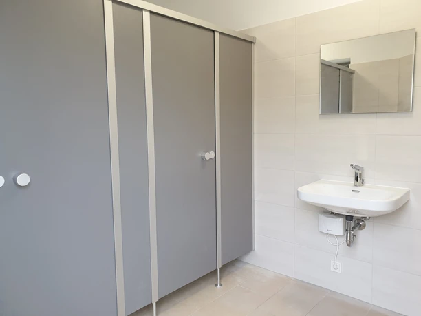 toilette_ti_werdum.jpg Zwei Türen einer Toilettentrennwand mit Waschbecken davor