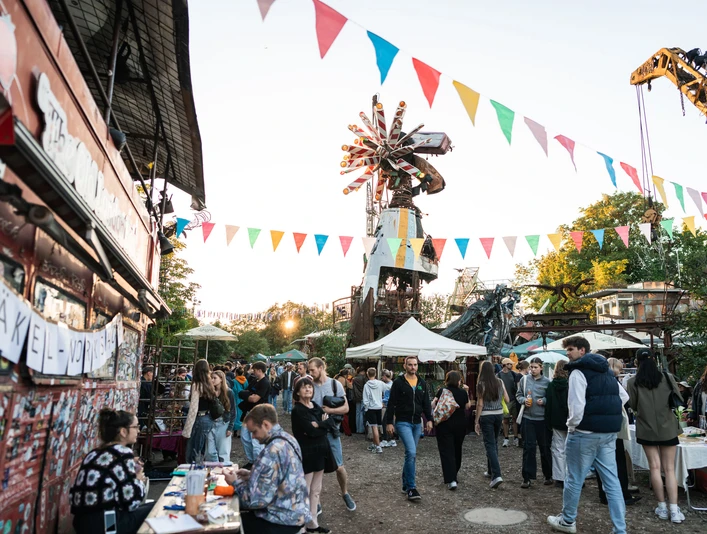 Odonien Ein lebhafter Markt mit bunten Wimpeln, fröhlichen Menschen und kreativen Skulpturen.A lively market with colorful bunting, cheerful people and creative sculptures.