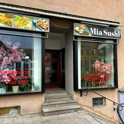 Eingang von Mia Sushi mit asiatischen Dekorationen und großem Fenster im urbanen Umfeld.