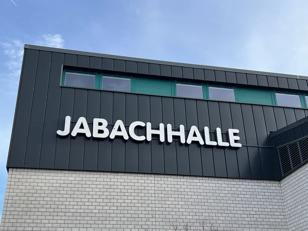 Jabachhalle Jabachhalle in Lohmar: modernes Gebäude mit dunkler Fassade und großen Fenstern unter klarem Himmel.