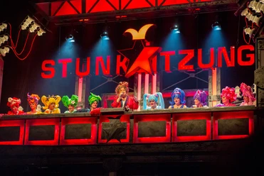 Stunksitzung Eine lebendig dekorierte Bühne mit kostümierten Künstlern, die Teil der Kölner Stunksitzung sind.