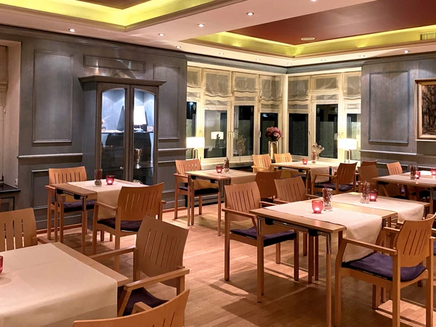 Blaues Zimmer im Schützenhof Paderborn Helles, elegant gestaltetes Zimmer mit Holzmöbeln und Kerzen auf weißen Tischdecken im Schützenhof.