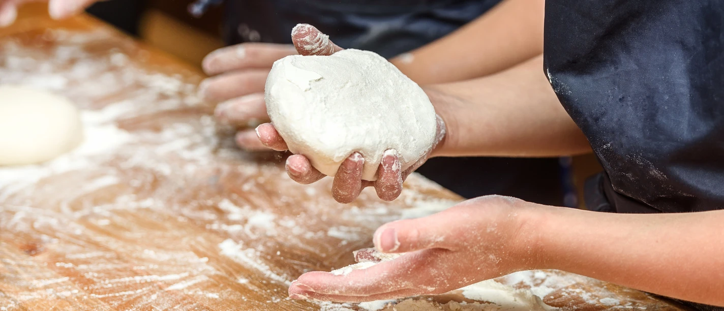 Close-up of children's hands preparing dough for pizza. Pizza, children and the concept of cooking - children make pizza. Close-up of children's hands preparing dough for pizza. Pizza, children and the concept of cooking - children make pizza.