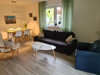 20230519_191547.jpg Moderne Ferienwohnung mit heller Sitzecke, Esstisch für vier Personen und gemütlicher Einrichtung.