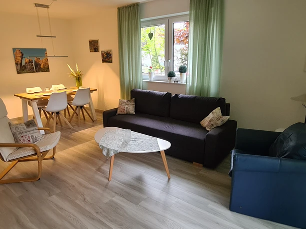 20230519_191547.jpg Moderne Ferienwohnung mit heller Sitzecke, Esstisch für vier Personen und gemütlicher Einrichtung.