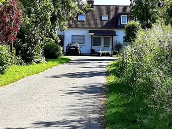 Hofladen Fiener Wohnmobilstellplatz Einfahrt.jpg Einfahrt zum Hofladen Fiener mit einem lang gestreckten Weg, umgeben von üppiger Vegetation.