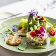 Fine Food Days Cologne Gehobene Küche, ein Teller mit schön angerichteten und mit Blumen dekorierten Speisen.Haute cuisine, a plate of beautifully arranged dishes decorated with flowers.