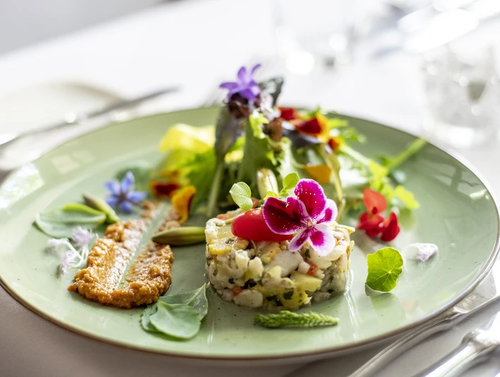 Fine Food Days Cologne Gehobene Küche, ein Teller mit schön angerichteten und mit Blumen dekorierten Speisen.Haute cuisine, a plate of beautifully arranged dishes decorated with flowers.