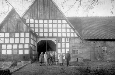 broederhausen-feuerwehrgeraetehaus.jpg Historisches Fachwerkgebäude mit Menschen in traditioneller Kleidung davor, aufgenommen in Broderhausen.