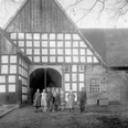 broederhausen-feuerwehrgeraetehaus.jpg Historisches Fachwerkgebäude mit Menschen in traditioneller Kleidung davor, aufgenommen in Broderhausen.