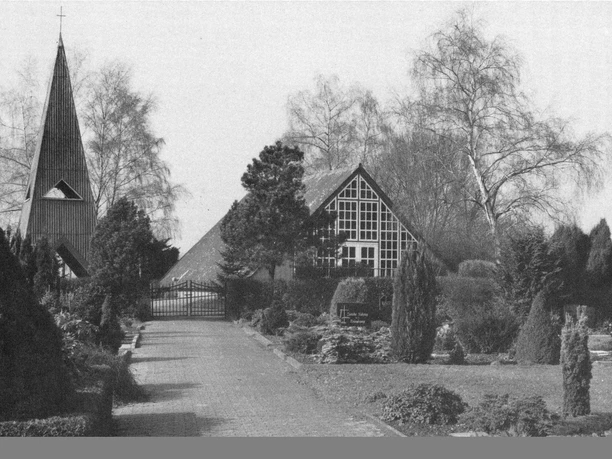 buettendorf-friedhofskapelle -frueher.jpg Die Friedhofskapelle Büttendorf steht umgeben von Bäumen und grünen Sträuchern neben einem Kirchweg.