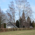 buettendorf-friedhofskapelle.JPG Eine Friedhofskapelle mit spitzem Turmdach, umgeben von kahlen Bäumen auf einem ländlichen Areal.