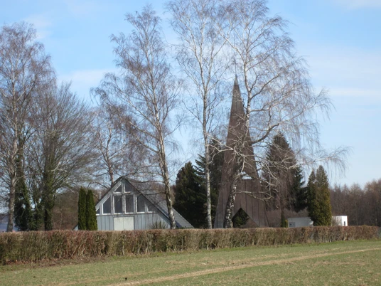buettendorf-friedhofskapelle.JPG Eine Friedhofskapelle mit spitzem Turmdach, umgeben von kahlen Bäumen auf einem ländlichen Areal.