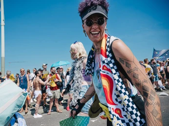 Cologne Pride Menschen genießen in bunter Kleidung und gelöster Atmosphäre den Cologne Pride unter blauem Himmel.People enjoy Cologne Pride under a blue sky in colorful clothing and a relaxed atmosphere.
