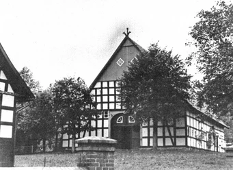 holsen-hof-sielermann.jpg Historischer Fachwerkhof, umgeben von Bäumen, mit Satteldach und mehreren großen Fenstern, ländlich gelegen.