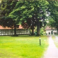 holsen-hof-sielermann-heute.jpg Ein historischer Hof mit Fachwerkgebäuden, umgeben von grünem Rasen und großen alten Bäumen.