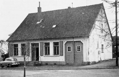 huellhorst-rathaus-alt.jpg Historisches Rathaus in Hüllhorst mit einem Satteldach, alten Fenstern und einem davor geparkten Oldtimer.
