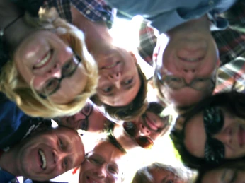 Auf geht's - Team Köln Gruppe von Personen steht im Kreis und schaut nach unten in die KameraGroup of people standing in a circle and looking down into the camera