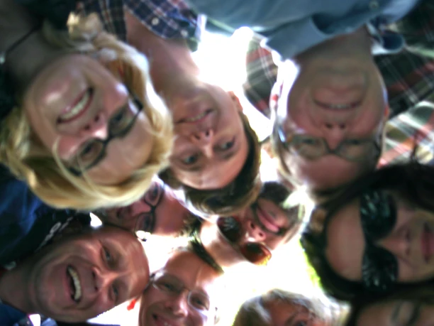 Auf geht's - Team Köln Gruppe von Personen steht im Kreis und schaut nach unten in die Kamera