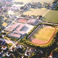 huellhorst-gesamtschule.jpg Luftaufnahme einer Schule in einer ländlichen Gegend mit Sportplatz, umgeben von Feldern und Wohnhäusern.