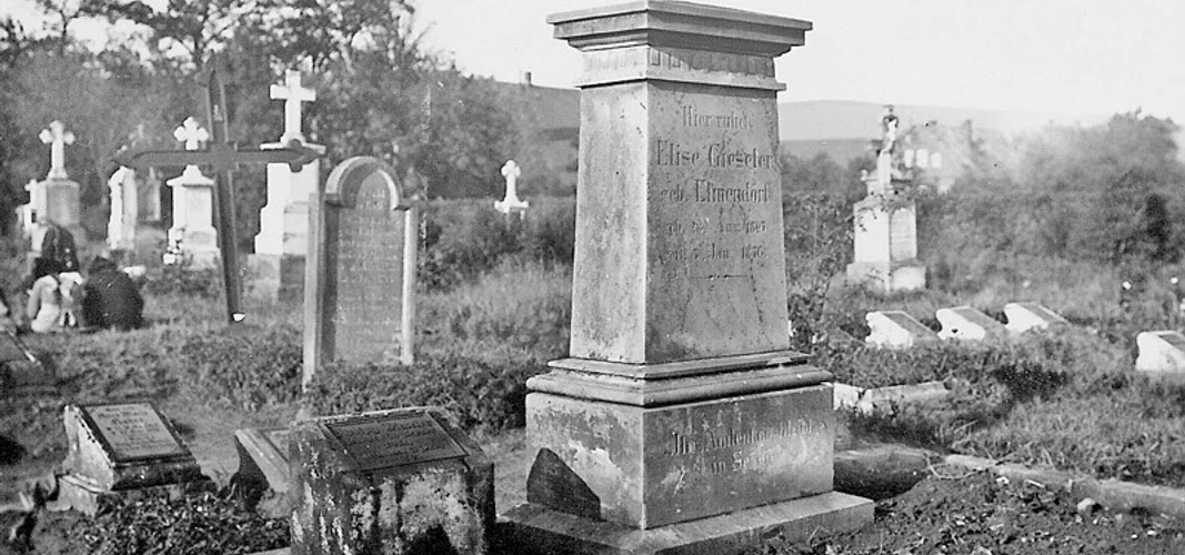 huellhorst-alter-friedhof.jpg Alter Friedhof mit verwitterten Grabsteinen und einem dominanten zentralen Monument, umgeben von Bäumen.