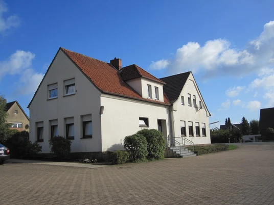 oberbauerschaft-dorfgemeinschaftshaus-neu.jpg Dorfgemeinschaftshaus Oberbauerschaft mit weißer Fassade, rotem Dach und barrierefreiem Zugang.