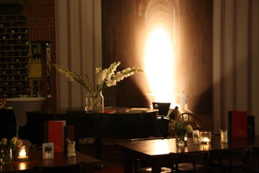 Kölner DinnerTour Dinnertische mit Piano im Hintergrund