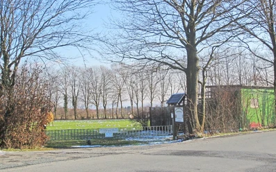 oberbauerschaft-alter-sportplatz-03.jpg Alter Sportplatz mit kahlen Bäumen im Hintergrund, winterlich, mit Schnee bedeckt, ruhige Umgebung.
