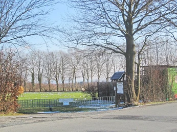 oberbauerschaft-alter-sportplatz-03.jpg Alter Sportplatz mit kahlen Bäumen im Hintergrund, winterlich, mit Schnee bedeckt, ruhige Umgebung.