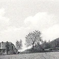 oberbauerschaft-koepperplatz-03.jpg Schwarzweißaufnahme eines kleinen Landhauses mit Bäumen, auf einer weitläufigen Wiese gelegen.