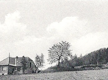 oberbauerschaft-koepperplatz-03.jpg Schwarzweißaufnahme eines kleinen Landhauses mit Bäumen, auf einer weitläufigen Wiese gelegen.