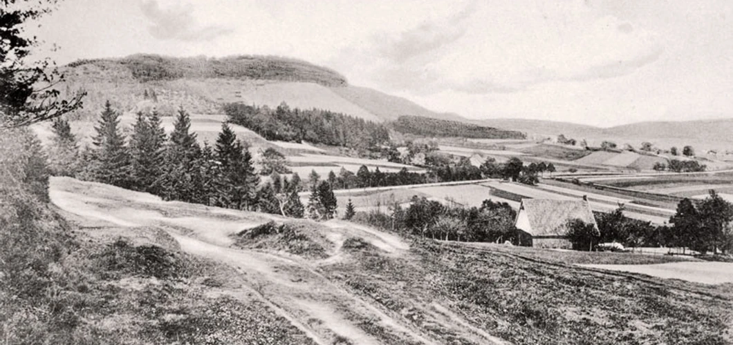 oberbauerschaft-augustus-hoffmann-bank-01.jpg Historische Schwarzweiß-Aufnahme des Wiehengebirges mit hügeliger Landschaft und vereinzelt stehenden Bäumen.