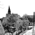 schnathorst-hof-niedermeier-03.jpg Fachwerkhäuser in einer Dorfansicht mit einer Kirche im Hintergrund, winterliche Baumkronen säumen die Straße.