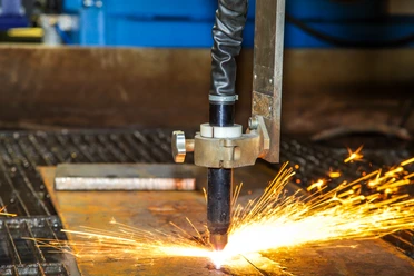 Handwerk Ein Schneidbrenner durchtrennt Metall, während Funken sprühen. Einblick in handwerkliche Präzision.