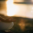 Sungazing. Woman Sun Gazing and Meditating by the Lake in Lotus Position. Sungazing. Woman Sun Gazing and Meditating by the Lake in Lotus Position.