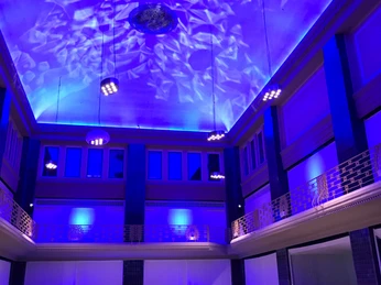 Restaurant KWB im Stadtpalais Zauberhaft beleuchteter Festsaal mit elegant gedeckten Tischen und blauer Deckenbeleuchtung.Enchantingly lit ballroom with elegantly laid tables and blue ceiling lighting.