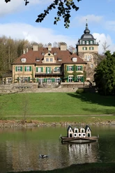 Schloss Lerbach Das Bild zeigt das malerische Schloss Bensberg mit einem kleinen Teich und Enten im Vordergrund.
