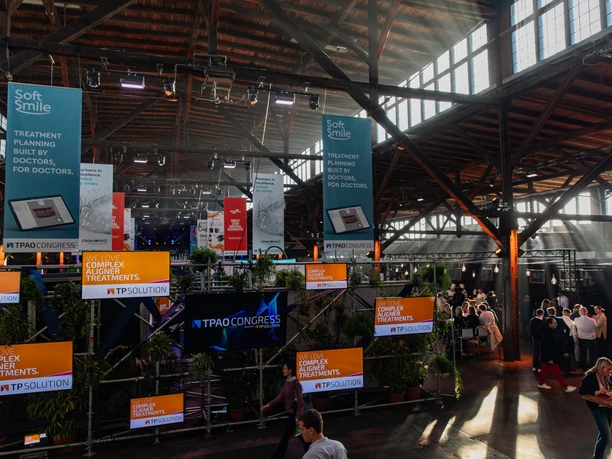 Kongress TPAO Hamburg, Schuppen 52 Bright conference hall with modern stands and visitors, flooded with natural light</p>.