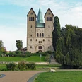 Abdinghofkirche Abdinghofkirche in Paderborn vor blauem Himmel, umgeben von grünen Rasenflächen und Bäumen.