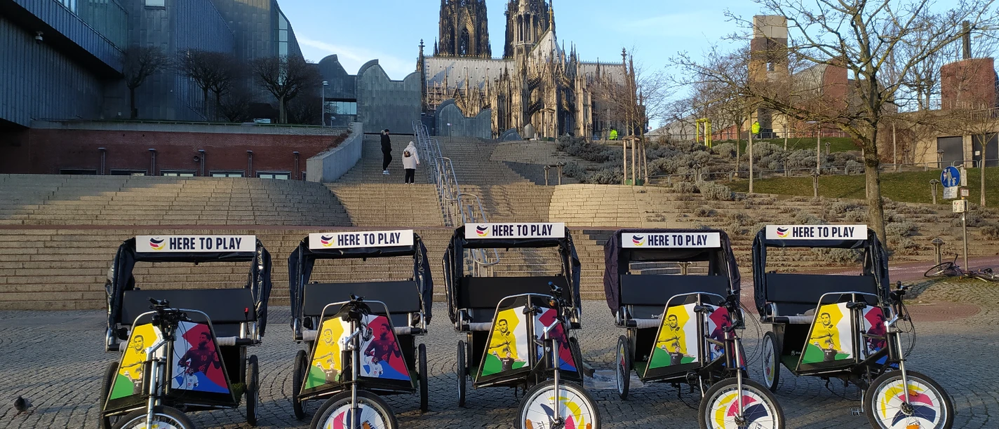Rikolonia_Event Branding.jpg The colorful bicycle rickshaws stand in front of the impressive Cologne Cathedral at dusk.
