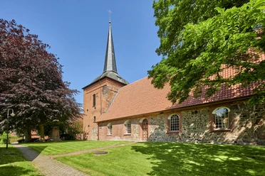St. Vitus Kirche Belum Historische St. Vitus Kirche in Belum mit Backsteinfassade und spitzem Turm im Sonnenlicht.