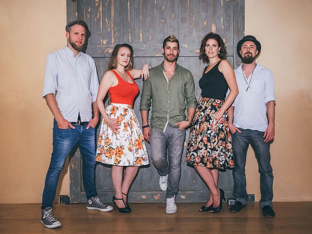 reinakustisch-akustikband-event-party-11.jpg Fünf Personen in Freizeitkleidung posieren vor einer Holztür, lässig und selbstbewusst.</p>