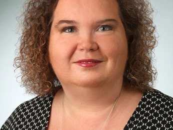 Profilbild Katja Grabbe-Lange Katja Grabbe-Lange lächelt freundlich in die Kamera; sie trägt ein schwarz-weißes gemustertes Oberteil.