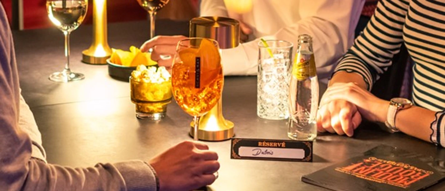 MDK_Gruppe_1 Eine gemütliche Bar, Menschen bei Getränken, gedimmtes Licht, atmosphärisch und gesellig.