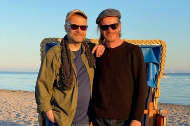 Foto TJ & Berger_2560x1707.jpg Zwei Männer am Strand mit Sonnenbrillen