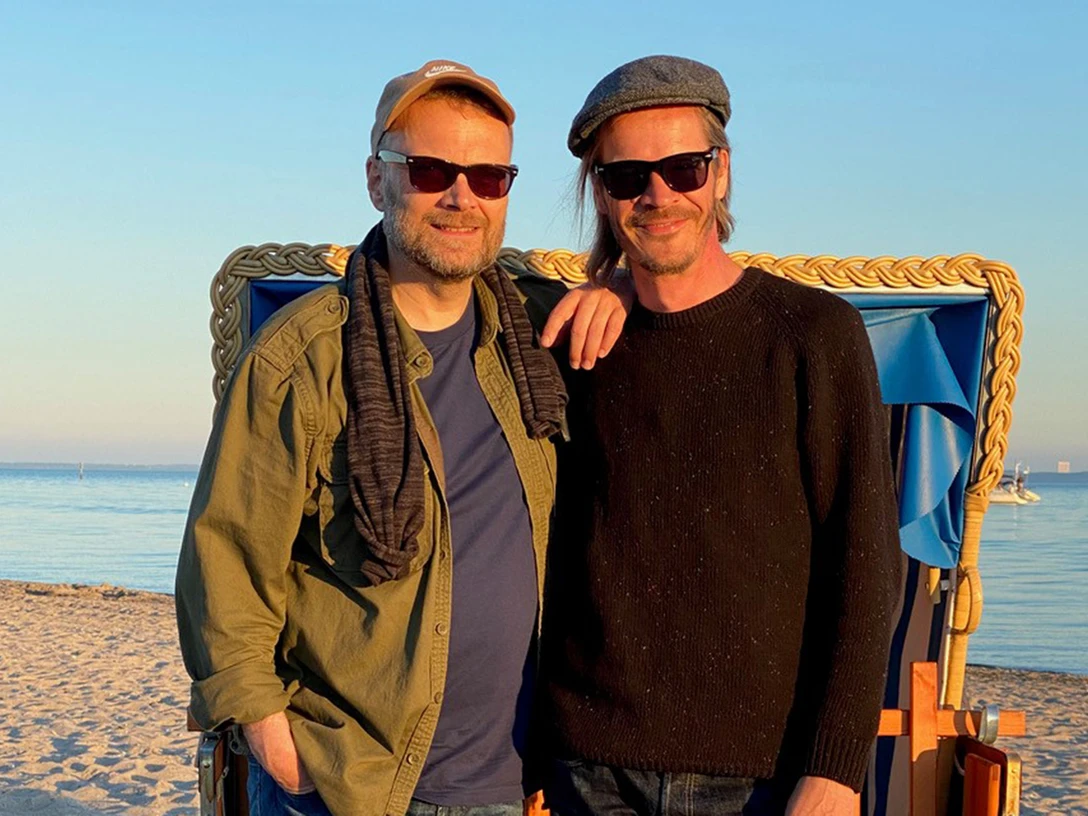 Foto TJ & Berger_2560x1707.jpg Zwei Männer am Strand mit Sonnenbrillen