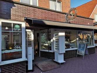 Building made of red bricks with white showcases at the entrance.