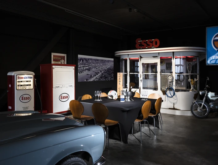 04_CC_PrivateDinner.jpg Retro-Essenzapfsäule und Esso-Diner mit Oldtimer-Motorrad in einem nostalgischen Ausstellungsraum.Retro petrol pump and Esso diner with vintage motorcycle in a nostalgic showroom.